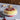 Alessi Mattina Cake Stand With Dome Lifestyle Image 1 shows a beautifully designed cake presentation set that combines elegance and functionality, perfect for showcasing and preserving your delicious cakes and pastries.