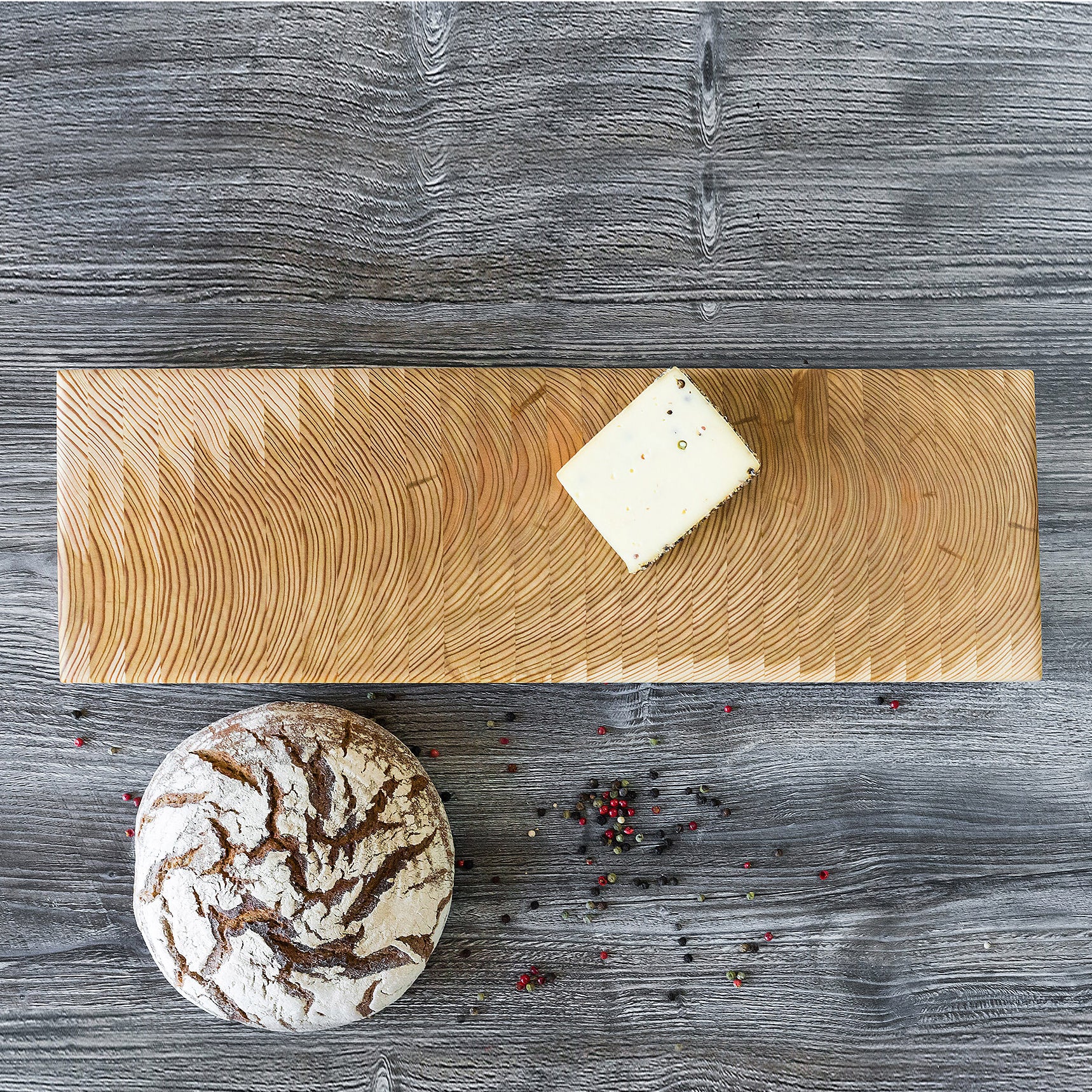 A loaf of bread and a piece of butter on a wooden cutting board